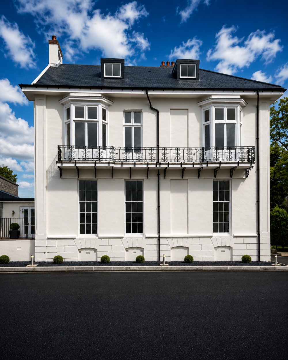 Riversvale Villa — restored villa exterior with wrought-iron balconies under a blue sky