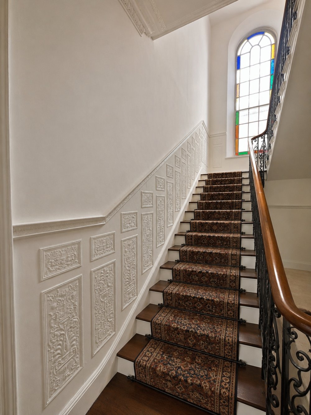 Riversvale Villa — ornate plasterwork stairwell with a stained-glass window and runner